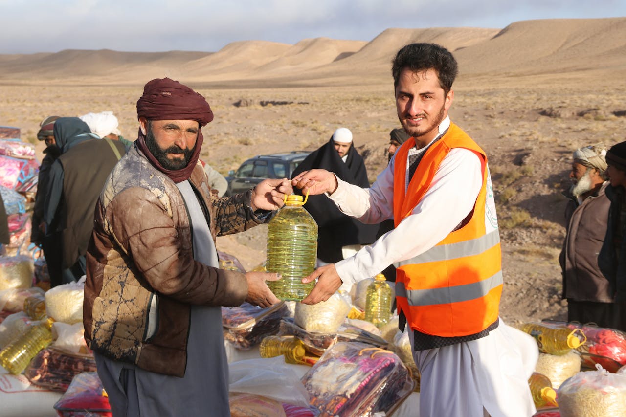 services-01 Community members receive supplies during a humanitarian aid distribution in a desert village.